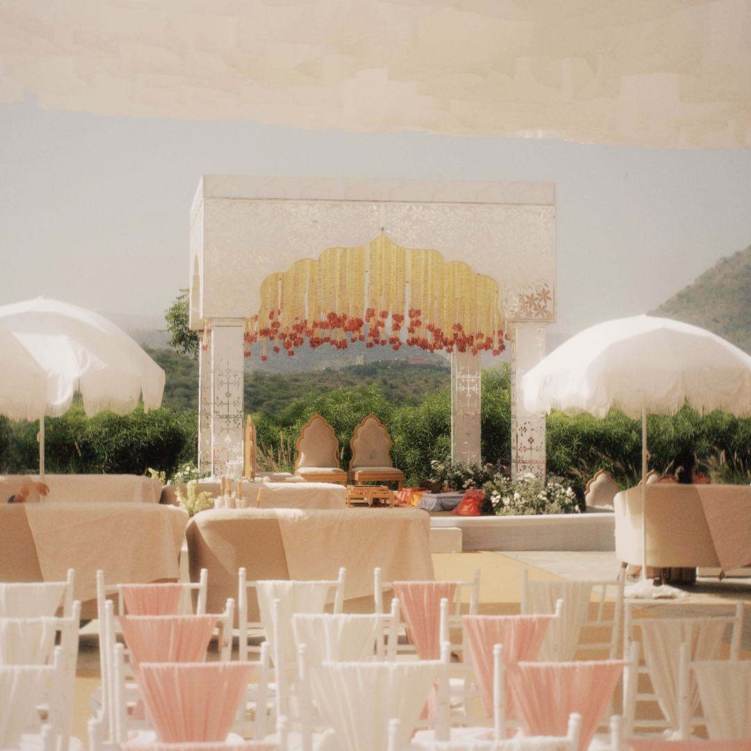 A mandap and reception tables set up outdoors before an Indian wedding